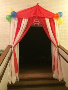 an entrance to a party with balloons on the ceiling and drapes over the door