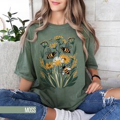 This Bee Flower Graphic T-Shirt offers a beautiful aesthetic with its vibrant design. Perfectly blending boho and cottagecore styles, this shirt is an ideal gift for her or any nature lover. The shirt features a charming bee and flower design, giving it a vintage feel that is both trendy and timeless. Great for casual wear or as an oversized tee, this comfort colors shirt is sure to be a favorite in any wardrobe. 🌟 Need Help or Returns? 🌟 If you have any questions or need assistance, reach out Fairycore Clothing, Boho Tshirts, Bee Flower, T Shirt Aesthetic, Cottagecore Shirt, Aesthetic Shirt, Cottagecore Style, Beautiful Aesthetic, Bee On Flower