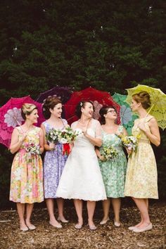 a group of women standing next to each other holding umbrellas