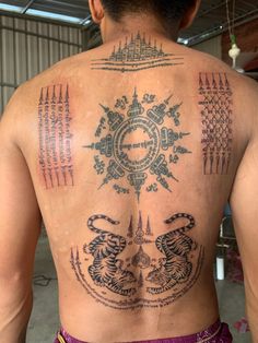 the back of a man with tattoos on his body