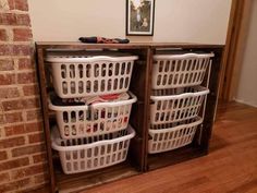 several laundry baskets are stacked on top of each other in front of a brick wall