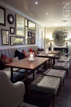 a restaurant with tables, benches and pictures on the wall above them that have candles in front of them