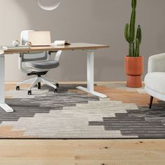 an office with a desk, chair and potted cactus in front of the table