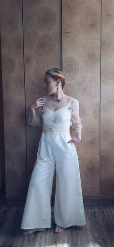 a woman standing in front of a wooden wall