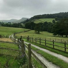 a wooden fence in front of a lush green field