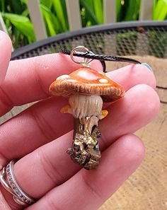 Fairies! Here is your dream necklace! A hand scuplted, gorgeously detailed mushroom growing from a real crystal shard! What can make this even better? It glows in the dark! Made from polymer clay and crystal shard then coated with an enamel gloss for durability and shine. This is water-resistant but I wouldn't recommend wearing it in water. Strung from an 18" black leather cord. All orders will be shipped within 3 business days of payment unless otherwise noted. In an effort to go green, I do no Clay Mushroom Pendant, Polymer Clay Mushroom Design Jewelry Gift, Whimsical Brown Jewelry For Gifts, Whimsical Brown Jewelry Gift, Whimsical Brown Jewelry For Gift, Unique Adjustable Mushroom-shaped Jewelry, Mushroom Crystal Necklace, Crystal Shard, Mushroom Crystal