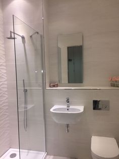 a bathroom with a toilet, sink and shower stall