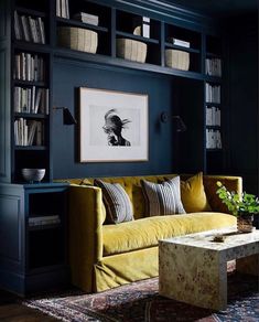 a living room with bookshelves and a couch in the corner, next to a coffee table