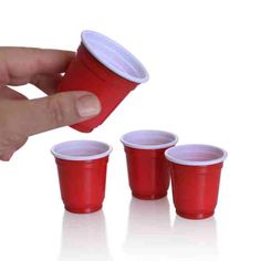 a hand holding a red plastic cup with four cups in front of it and three smaller ones behind it