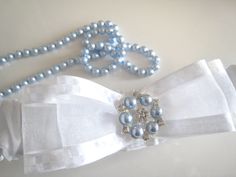 Exclusive luxury personalised wedding garter made using a gorgeous satin shantung. As this is a satin band garter it fits fairly flat against the leg. Decorated on the front with a double organza bow which has a diamante and Swarovski blue pearl button in the centre. This style looks lovely on, really classy but not too over the top. The buttons are unique to my site and so you will not find this garter anywhere else. Hidden on the inside back is the bride new surname. If preferred I can embroid Personalized Wedding Garter, Wedding Garter, Blue Pearl, Bride Gifts, Personalized Wedding, Wedding Details, Satin, Band, Electronic Accessories