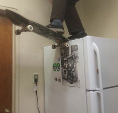 a person standing on top of a white refrigerator