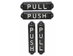 two metal signs that say pull push and he's pulling the button on them