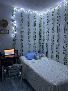 a bed room with a neatly made bed and string lights on the wall behind it