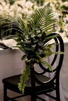 a chair with a plant on it sitting in front of a table full of flowers