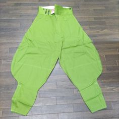 a pair of green pants sitting on top of a wooden floor