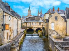 a river running through an old city next to tall buildings