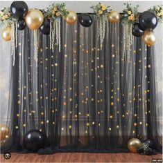 black and gold balloons are hanging from the sheer curtain