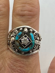 For your consideration I have a beautiful handmade Sterling Silver Turquoise and cubic zirconia Native American ring that has a marking of CW. This ring is used. Please note that the one part of the horseshoe that holds the turquoise it is damaged. Still with that this ring is beautiful. This ring is a size 12 3/4 and weighs 11.4 grams. The horseshoe measures 14mm wide and 14mm tall. Turquoise Sterling Silver Jewelry With Center Stone, Southwestern Multi-stone Jewelry For Anniversary, Southwestern 925 Stamped Jewelry For Anniversary, Luxury Turquoise Diamond Ring With Center Stone, Bohemian Inlay Jewelry For Anniversary, Western Sterling Silver Gemstone Ring, Western Style Sterling Silver Gemstone Ring, Western Style Turquoise Sterling Silver Ring, Western Style Turquoise Ring Stamped 925