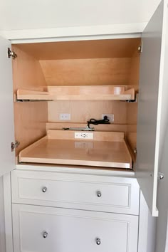 an empty white cabinet with drawers in it