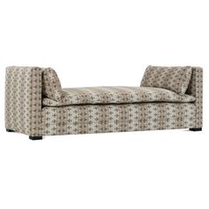 an upholstered chaise lounger in beige and brown patterned fabric with black legs