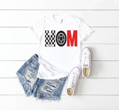 a white shirt with the word mom printed on it next to ripped shorts and sneakers