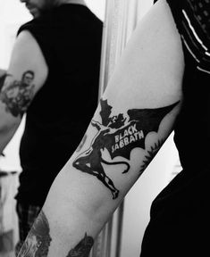 a man with a batman tattoo on his arm