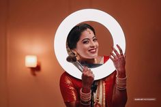 a woman holding a mirror with her hands in front of her face and smiling at the camera