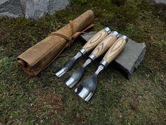 four wooden utensils are laying on the ground