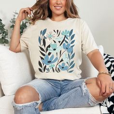 Boho Wildflowers T-Shirt in Blue and Teal. Looking for a cute shirt to wear this spring and summer? Or a sweet gift for a nature lover, wildflower enthusiast, plant lover, or flower gardener? Then take a look at this oh-so-pretty Boho floral tee with its simple, elegant blue and teal flower design. It's perfect classy yet casual wear, and it makes a lovely birthday, Mom's Day, and any day gift for ladies who like pretty things. Available in 9 flattering colors. HOW TO ORDER 1) Choose the shirt s Blue Floral Print Graphic Tee, Blue Graphic Tee With Floral Print, Blue Floral Print Graphic Tee Shirt, Botanical Short Sleeve Cotton Tops, Botanical Screen Print Tops For Spring, Botanical Style Screen Print Tops For Spring, Botanical Style Short Sleeve Cotton Tops, Botanical Cotton Tops With Short Sleeves, Botanical Graphic Print Cotton Shirt