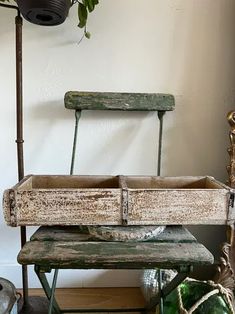 an old wooden bench sitting next to a potted plant on top of a table