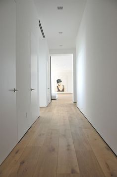 an empty hallway with white walls and wooden floors