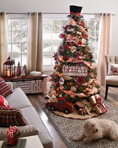 a living room with a christmas tree decorated in red and white ribbons, plaid throw pillows, and a dog laying on the floor