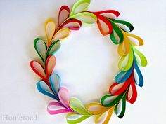 an image of a colorful wreath made out of strips of colored paper with the words fold strips into a colorful wreath