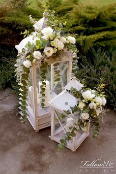 a white lantern with flowers and greenery on it