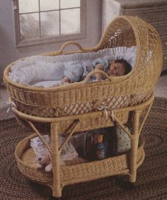 a baby laying in a wicker bassinet on top of a carpeted floor