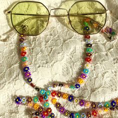 This handmade colorful eyeglasses chain is painstakingly hand-stitched with the finest quality glass seed beads. Thanks to the light beaded daisy chain necklace that you can use in all seasons, your glasses will not be lost. Lenght 80 cm 31,5 in                                                                                                                                                           Guaranteed to receive all compliments thanks to the eyeglasses holder that adapts to all your outfit Summer Glass Necklace Fashion Accessory, Summer Fashion Glass Necklace, Beaded Clear Glass Glasses Chains, Summer Glass Chain Necklaces, Clear Beaded Glass Glasses Chains, Glass Chain Necklaces For Summer, Summer Glass Chain Jewelry, Trendy Glass Jewelry For Festivals, Trendy Glass Festival Jewelry