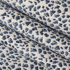 a blue and white animal print fabric with black spots on the top, while it's texture is slightly blurry