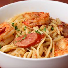 a white bowl filled with pasta and shrimp