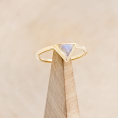 a yellow gold ring with a triangle shaped stone