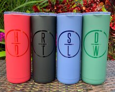 three different colored tumbles sitting next to each other on a wicker table with flowers in the background