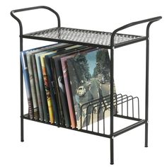 a metal rack with cd's and cds on it is holding various records, magazines or dvds