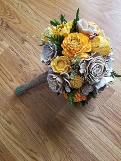 a bridal bouquet with yellow and grey flowers