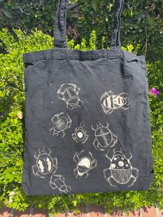 a black tote bag with drawings on it