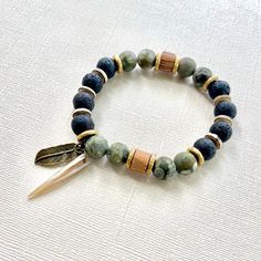 The green beaded bracelet is an authentic piece of Native American jewelry, inspired by nature and crafted in a bohemian style. This spiritual protection bracelet is perfect for men seeking a meaningful and culturally significant accessory. 🪶 𝗠𝗔𝗧𝗘𝗥𝗜𝗔𝗟𝗦 + 𝗗𝗜𝗠𝗘𝗡𝗦𝗜𝗢𝗡𝗦 ❯  10mm Rhyolite, Jasper, Wood, Abalone Shell, Brass ❯  Heavy Duty Elastic Cording 🪶 𝗦𝗧𝗢𝗡𝗘 + 𝗘𝗟𝗘𝗠𝗘𝗡𝗧 𝗘𝗡𝗘𝗥𝗚𝗬 ❯  NUMEROLOGY POWER OF 1 signifying courage, focus, will, and enlightenment ❯  RHYOLITE offers the energy of self-esteem ❯  JASPER clears electromagnetic and environmental pollution ❯  WOOD symbolizes life, growth and strength 🪶 𝗣𝗘𝗥𝗦𝗢𝗡𝗔𝗟𝗜𝗭𝗔𝗧𝗜𝗢𝗡 + 𝗚𝗜𝗙𝗧 𝗦𝗘𝗧 𝗦𝗨𝗚𝗚𝗘𝗦𝗧𝗜𝗢𝗡𝗦 ❯  Wood Bracelet Tray, with or without a monogram + cotton travel bag (photo 7) ❯  Ar Nature-inspired Adjustable Beaded Bracelet With Round Beads, Bohemian Gemstone Beads Friendship Bracelets, Green Hand-strung Bracelet For Meditation, Bohemian Braided Bracelets With Round Beads For Healing, Adjustable Nature-inspired Beaded Bracelets, Green Beaded Bracelets For Gifts, Nature-inspired, Artisan Wooden Beads Bracelets For Meditation, Artisan Green Beaded Bracelets For Beach, Earthy Beaded Bracelets With Natural Stones For Meditation