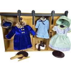 a doll's wardrobe with clothes and shoes for dolls, including a blue coat