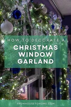 a christmas tree with blue and white ornaments hanging from it's branches in front of a window