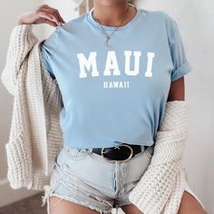 a woman wearing a blue shirt with the word mau in white letters on it