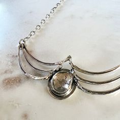 A gorgeous faceted clear topaz set in a handmade bezel, nestled between solid sterling silver castings of squirrel ribs. Beneath the sparkling topaz is a stamping of a single snowflake. The chain is delicate, but sturdy and measures 20" with a lobster clasp closure.Center piece of necklace measures about 2.75" wideTopaz measures 11mm x 13mm Elegant Sterling Silver Faceted Necklace, Sterling Silver Necklace With Clear Gemstone, Elegant Faceted Clear Necklace, Silver Faceted Citrine Necklace, Squirrel Necklace, Silver Casting, Lobster Clasp, Bones, Topaz