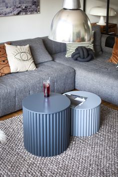 a living room filled with furniture and a large metal light fixture above the coffee table