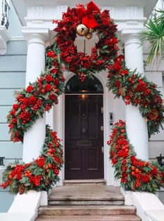 christmas wreaths and poinsettias decorate the front door of a house in charleston, ga